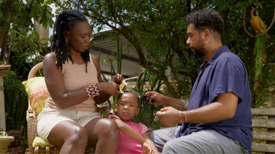 Mãe e pai brincam com a filha no quintal